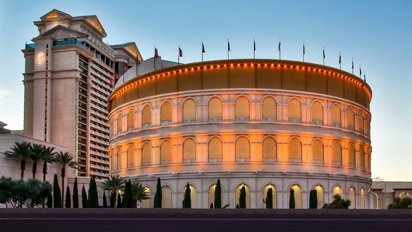 Booking a Caesars Las Vegas Hotel: Packages, Daily Credits and Cancellation Rules Explained Exterior of Caesars Palace in Las Vegas lit up in the evening