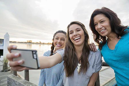 Friends taking a selfie together by the water