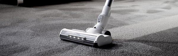 Gtech AirFOX Platinum stick vacuum cleaning a grey carpet