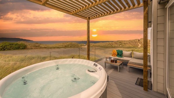 A hot tub on a covered terrace at sunset at St Ives Bay