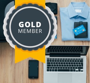 Maple Parking Gold Member badge on a desk with a laptop and phone