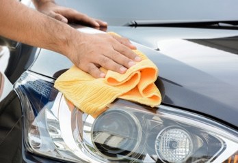 Hand polishing a car headlight during a valet