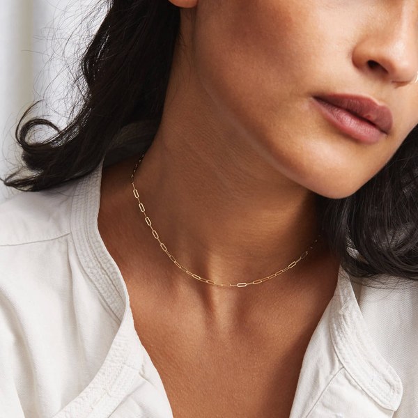 Woman wearing a fine gold Gldn paperclip chain necklace