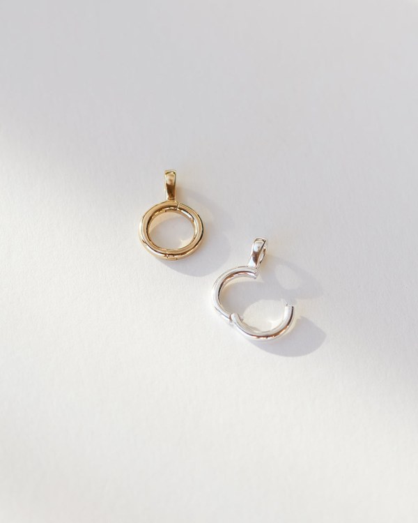 Gldn charm collector pendants in gold and silver shown open like small hoops