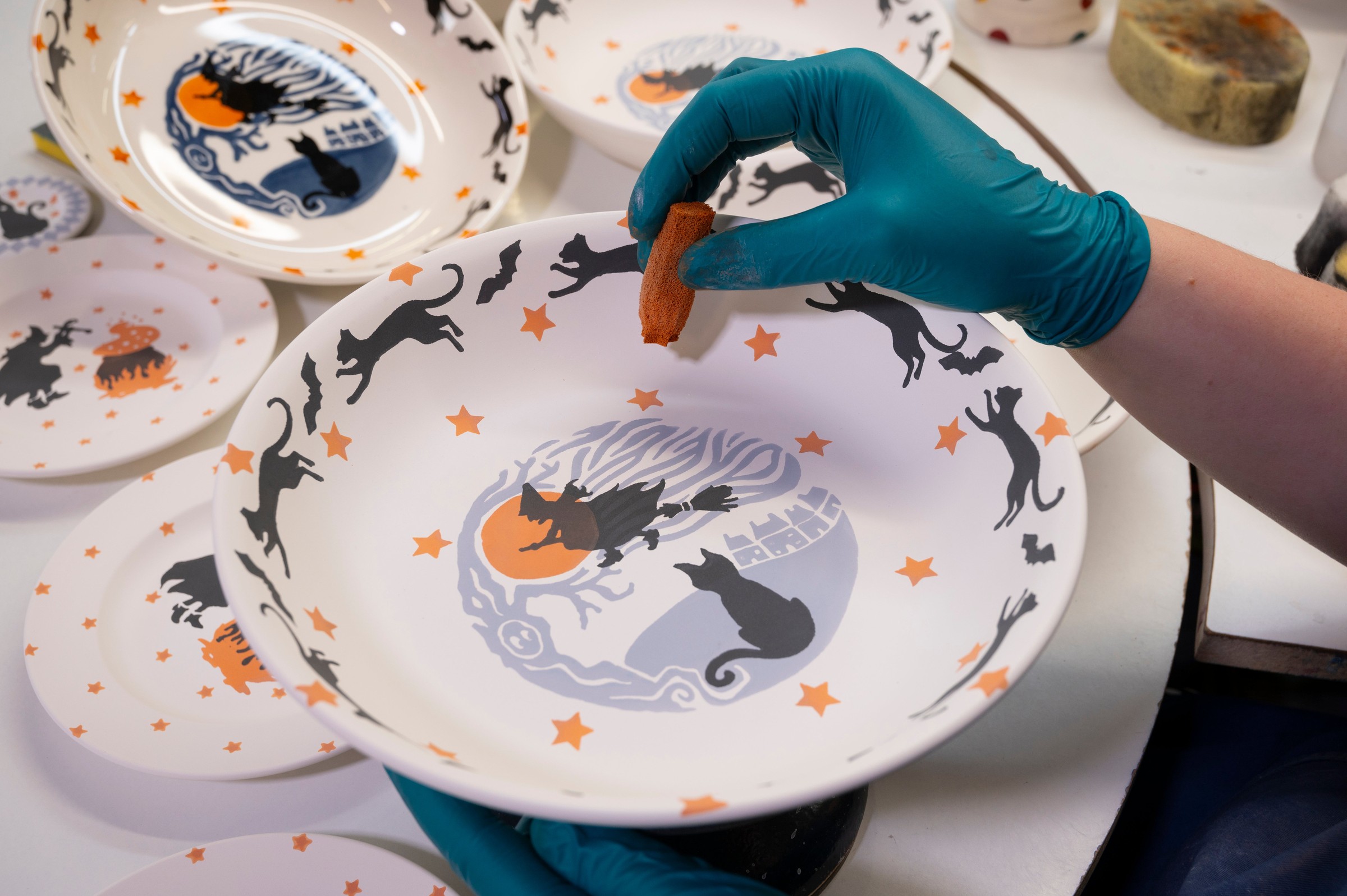 A decorator hand-sponging a pattern onto plates at the Emma Bridgewater factory