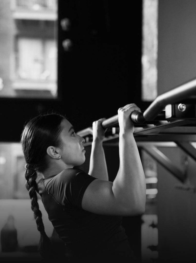 Woman doing pull-ups in a gym