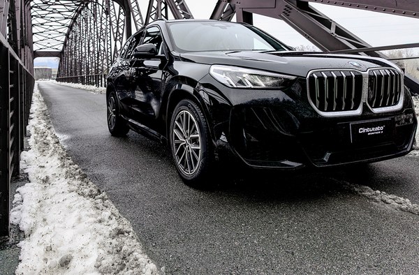 Black car with alloy wheels on a bridge in winter
