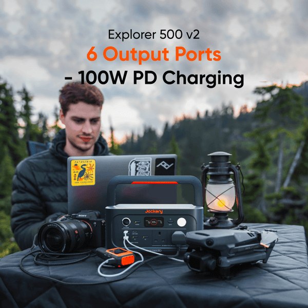 Man using a Jackery Explorer 500 v2 to power devices outdoors at night