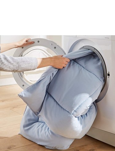 Chums All in One duvet being loaded into a washing machine